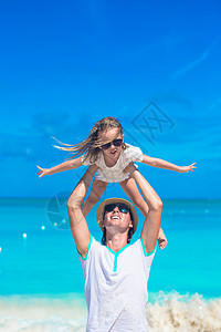在热带海滩度假时 年轻父亲和可爱的小女儿在热带沙滩度假图片