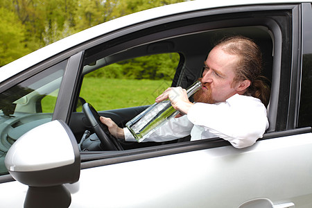 酒醉男人在车里喝着酒瓶酒运输男性瓶子司机汽车注意力监狱罪犯速度酒精图片