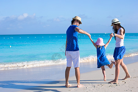 三口欢乐家庭 享受海滩度假女儿父亲孩子们女士母亲孩子男人假期男性异国图片