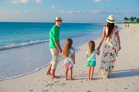 有两个孩子的年轻家庭 晚上有2个孩子在热带度假孩子们假期幸福海洋女孩父母男人享受阳光姐姐图片