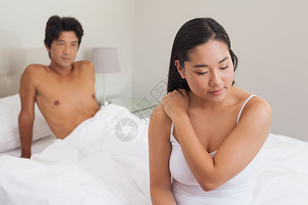 男朋友看着坐在床尾的女朋友 在看卧室思维膀子女性公寓男人房子夫妻羽绒被家庭图片