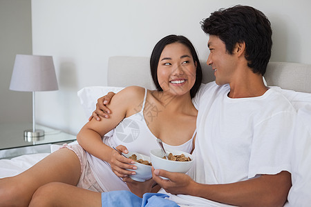 幸福的情侣在床上吃早餐闲暇家庭生活睡衣公寓男性拥抱谷物住所夫妻羽绒被图片