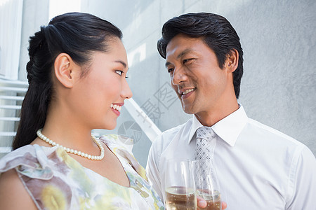 快乐的一对情侣穿了衣服 约会有香槟长笛微笑裙子领带住所奢华衬衫酒精家庭女性背景图片