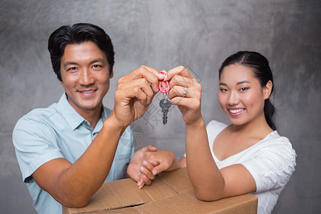幸福的一对夫妇拿着房子钥匙 靠着搬家箱盒子住所屋主倾斜女士男人夫妻家庭房地产闲暇图片
