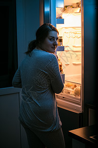 妇女深夜在冰箱里看照片图片