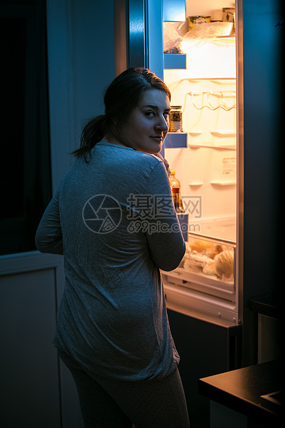 妇女深夜在冰箱里看照片图片