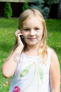 可爱的女孩通过手机聊天女士白色孩子金发童年细胞女性女学生电话背景图片