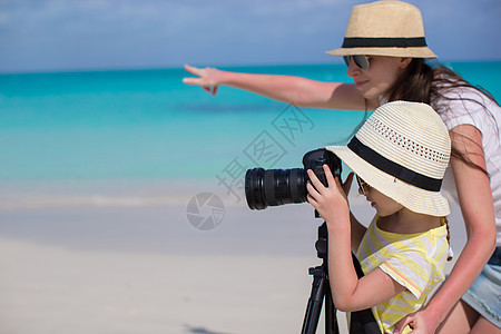 带照相机的小女孩和年轻母亲拍摄风景图片