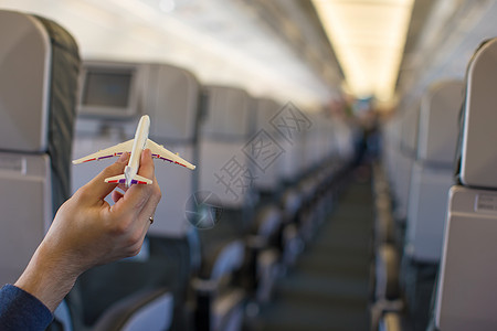 紧紧手握着一架大型飞机内的飞机型号男性乘客假期旅行铅笔员工飞机场男人翅膀客机图片