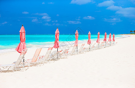 带雨伞和沙椅的热带空沙滩荒地天堂观景沿海情调天空海岸线海景椅子休息室晴天海滩海岸图片