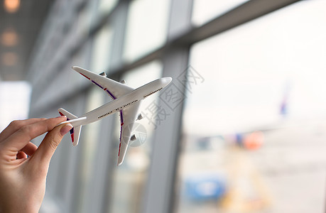 握着飞机型号的近手游客飞机场商务商业航程客机乘客翅膀运输航空公司背景图片