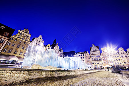 市场广场和著名的喷泉 在夜幕下开花店图片