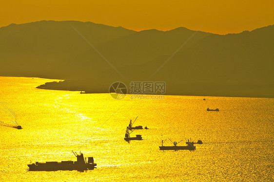 海中日落时散装货船反射海景日出日落油船商业船运天空出口海岸线图片