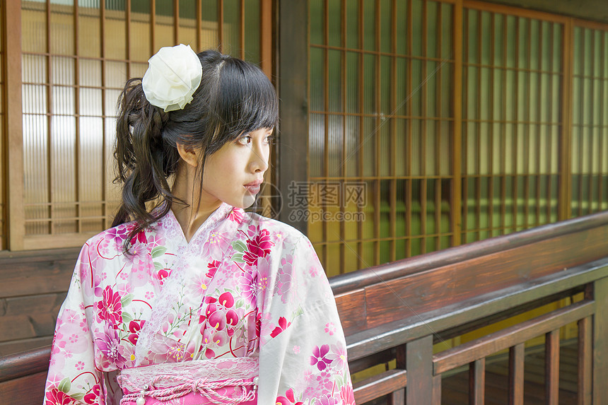 在日本风格的窗口前穿着浴衣的亚裔妇女图片