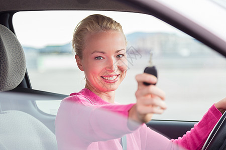 女司机出示车钥匙运输玻璃微笑车辆车轮喜悦女性快乐女孩成人图片