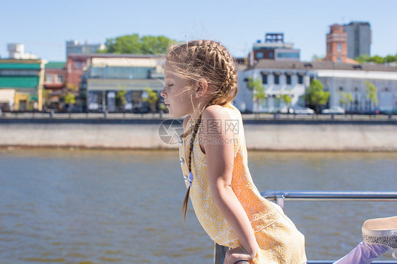 在大城市航行的船甲板上 可爱的小可爱女孩微笑晴天享受孩子海浪运输假期儿童帆船巡航图片