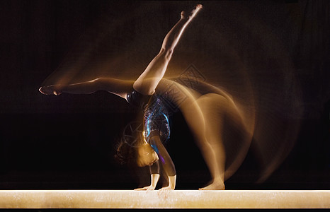 女性体操运动员在平衡波束上运动的多重暴露图像图片