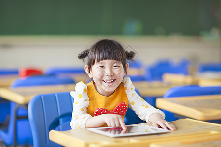 使用平板或ipad 微笑的孩子幼儿园学生班级课堂学习技术触摸屏电脑桌子青年图片