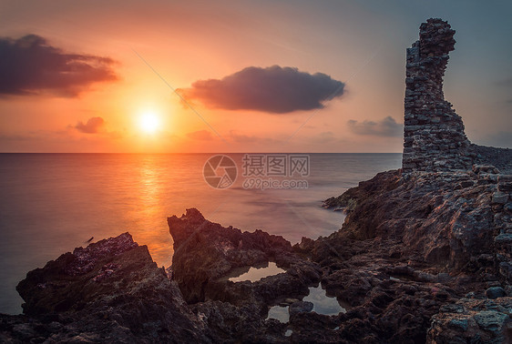 日落在海中橙子海洋石头海岸支撑反射海滩水池岩石废墟图片