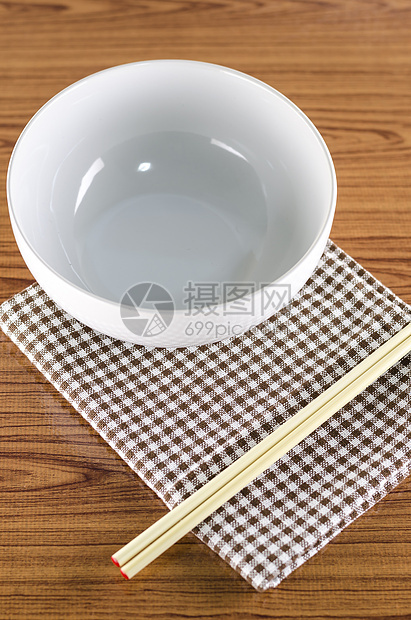 白碗和有厨房毛巾的筷子竹子圆形食物勺子黑色陶器用具木头盘子文化图片