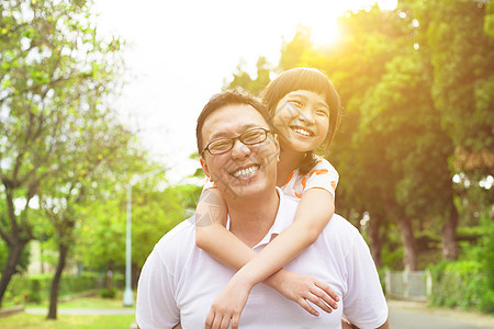 快乐的父亲和小女孩女儿乐趣阳光爸爸孩子微笑男人女孩家庭公园图片