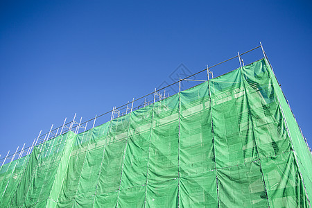 建筑建筑工地的绿色布面天空床单力量起重机蓝色工作脚手架毯子建筑物摩天大楼图片