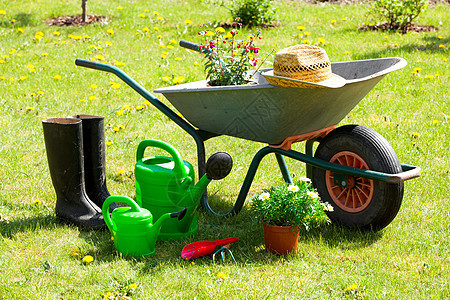 园艺工具和草帽 在花园的草地上花坛植物手套阳光稻草家政家庭作业种植生长紫色图片