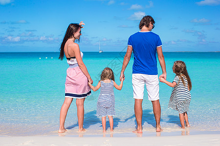 年轻家庭与两个孩子在卡利比恩度假的背影女士父母热带女孩旅行幸福假期女性父亲男性图片