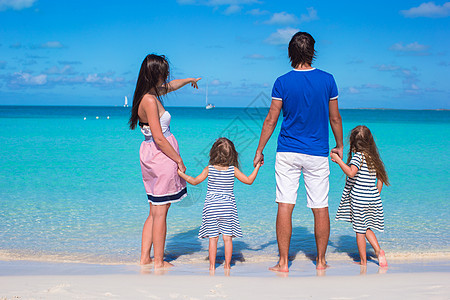 年轻家庭与两个孩子在卡利比恩度假的背影婴儿海滨男性幸福母亲海洋女孩爸爸父母海滩图片