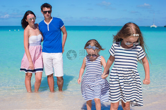 海滩度假时四口幸福的一家四口父母女士女孩爸爸女性母亲旅行孩子海洋成人图片