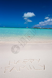 幸福的家庭写在热带沙滩白沙上海洋假期蓝色海景雕刻支撑天堂字母海浪海岸线图片