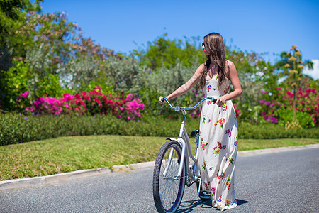 在热带度假胜地骑自行车的少女图片