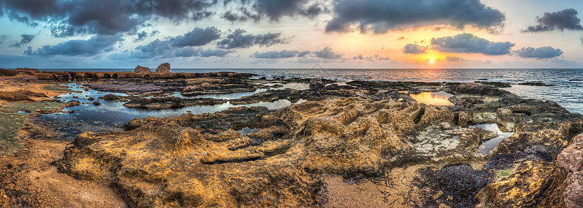 海边和岩石海岸的日落风景地平线海景海浪全景蓝色天空假期橙子太阳图片