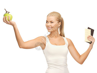 拥有苹果和巧克力棒的运动妇女微笑减肥饮食维生素重量化合物水果碳水酒吧生物图片