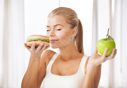 女人闻到汉堡和拿着苹果肥胖困境数字女孩脂肪保健卫生化合物营养伤害图片
