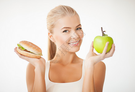 配有苹果和汉堡包的妇女减肥数字水果维生素福利运动困境垃圾低脂肪食物图片