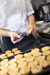 厨师准备甜点 从铸模中除去伴奏馅饼饮食用具男人糕点餐厅食堂工人烘烤图片