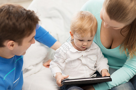 父母和可爱的婴儿与平板电脑Pc游戏选址长椅微笑药片母性女孩育儿男生拥抱图片
