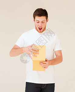 穿着白色T恤和带礼品盒的男子展示送货礼物妈妈们订婚生日丈夫男朋友微笑纸盒图片