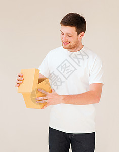 穿着白色T恤和带礼品盒的男子妈妈们周年邮政纸板礼物纸盒订婚微笑丈夫送货图片