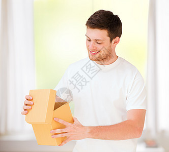 穿着白色T恤和带礼品盒的男子纪念日盒子丈夫送货纸板包装惊喜生日服务微笑图片