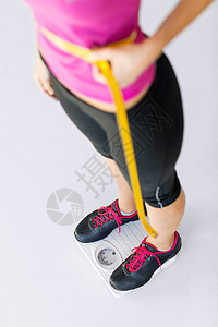 受过用测量胶带训练的腹部肌肉健康腰部肚子运动重量损失健身房女孩运动装图片