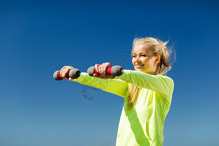 户外有轻哑铃的运动妇女训练运动装肌肉女孩教练健康锻炼天空减肥健身房图片