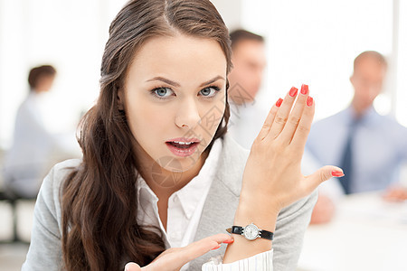 女商务人士指着她的手表女士商业工人女性企业家小时日程警告老板会议图片