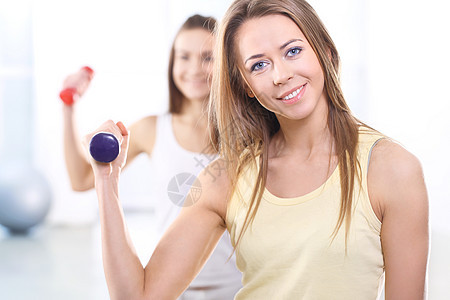在健身房培训有重体重的两名年轻妇女爱好活力弯曲体操皮肤幸福喜悦女孩哑铃朋友图片