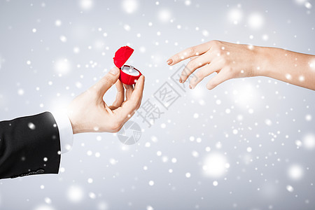 结婚戴戒指结婚戒指和礼品盒的夫妇未婚夫石头家庭展示雪花婚礼惊喜订婚礼物丈夫背景