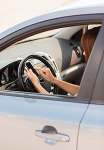 妇女驾驶汽车时使用电话注意力技术司机系统运输手机聊天城市专注旅行图片
