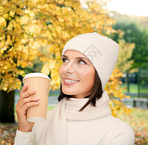 女人戴帽子 带外送茶叶或咖啡杯女性幸福女孩微笑食物毛衣生态快乐公园杯子图片
