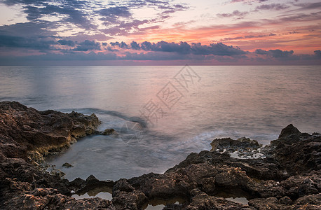 早晨落基海滩海景日落橙子支撑岩石天空石头旅行风景反射图片