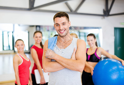 站在体育馆组前的微笑着的男人锻炼身体运动服成年人朋友们损失班级女性重量毛巾图片